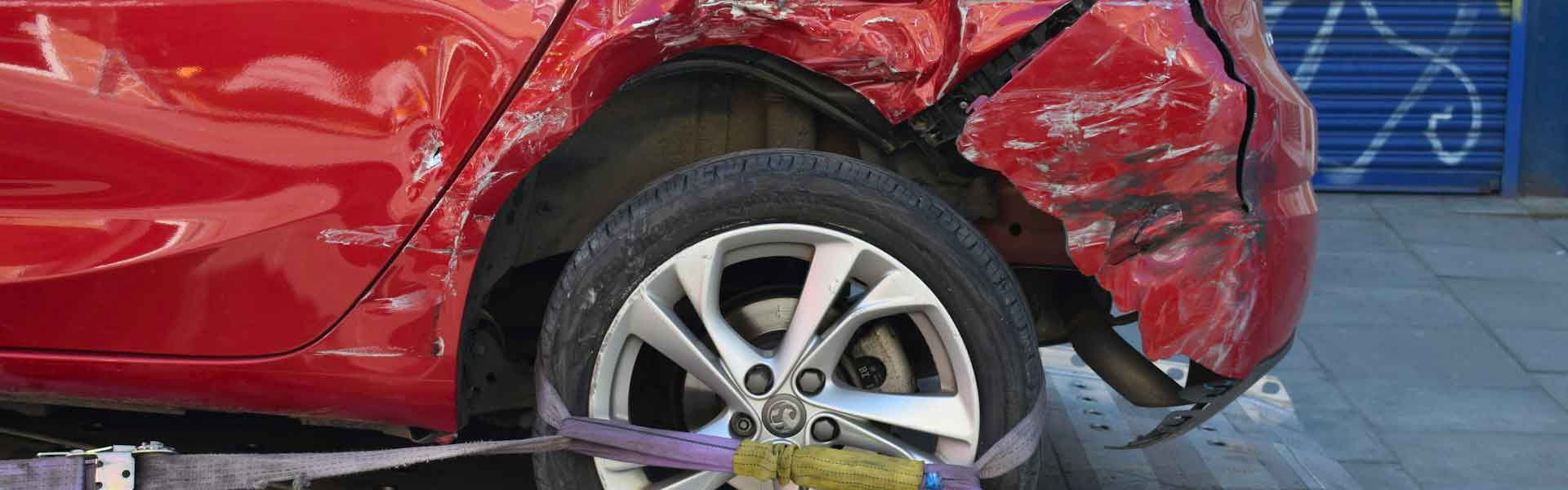 Véhicule accidenté sanglé sur un plateau avant enlèvement